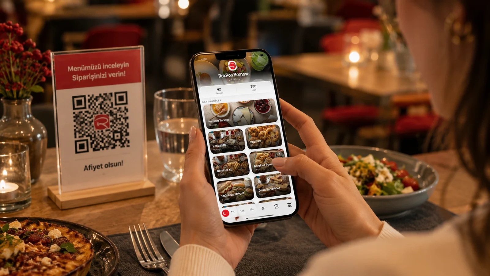 Un client scanne un menu QR avec son téléphone à la table d’un restaurant